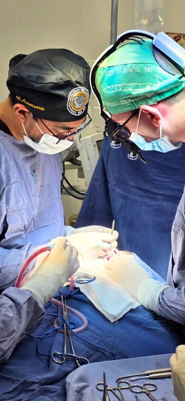 El Dr. Matheus Flores durante una cirugía maxilofacial, con lupas quirúrgicas